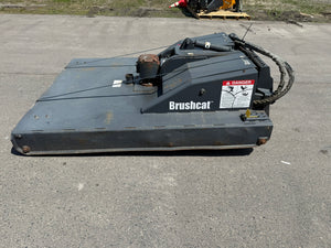Brushcat machine on a paved surface with grass in the background