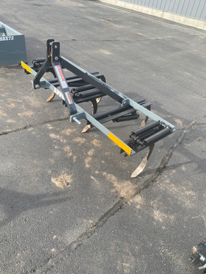 Heavy-duty agricultural implement on a cracked asphalt surface
