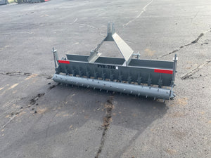Gray agricultural tiller on a cracked asphalt surface