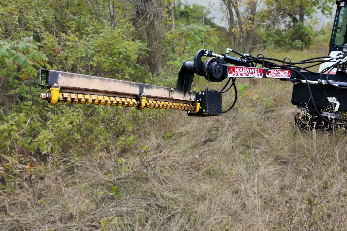 Junior Limb Cutter extended horizontally from a skid steer toward brush.