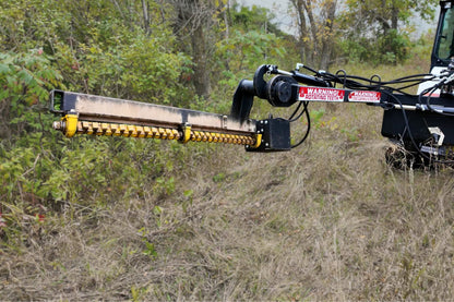 Junior Limb Cutter extended horizontally from a skid steer toward brush.