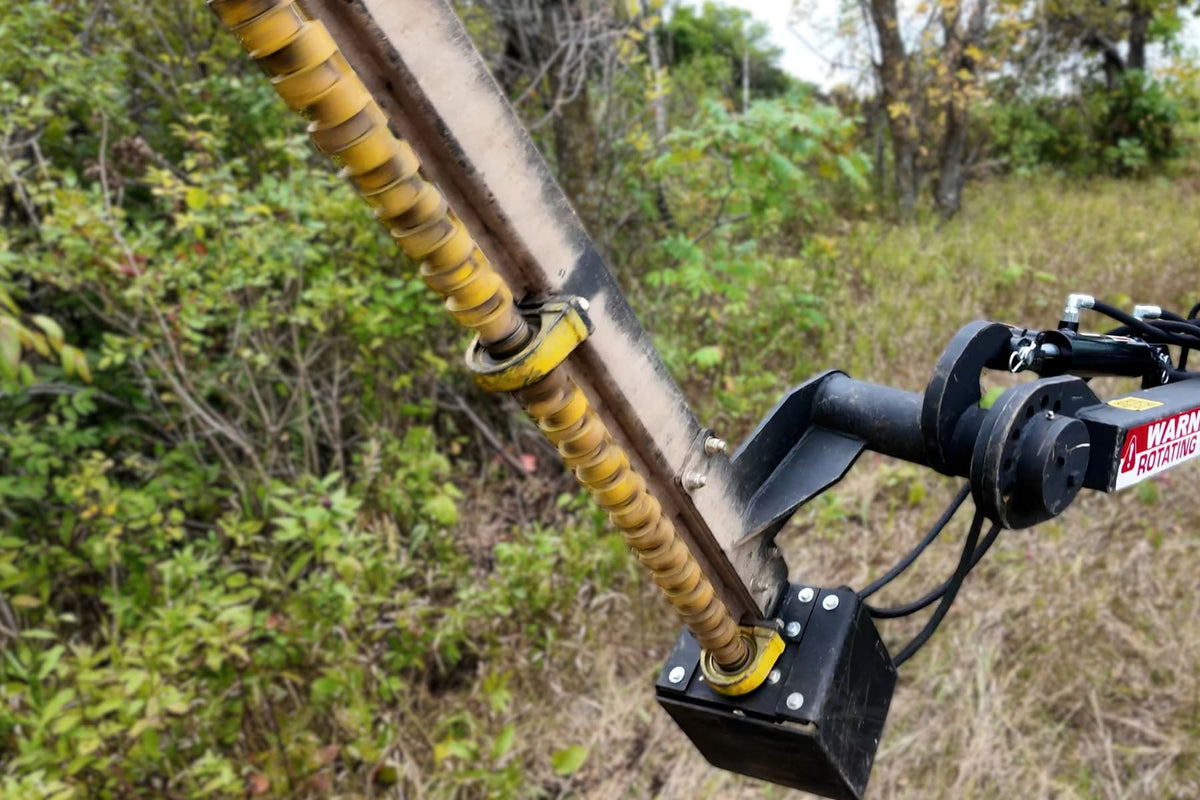 Close-up of the Junior Limb Cutter angled into branches, showing its yellow cutting rotor and mounting arm.