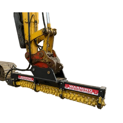 A yellow excavator limb cutter attachment with a long horizontal drum and warning labels.