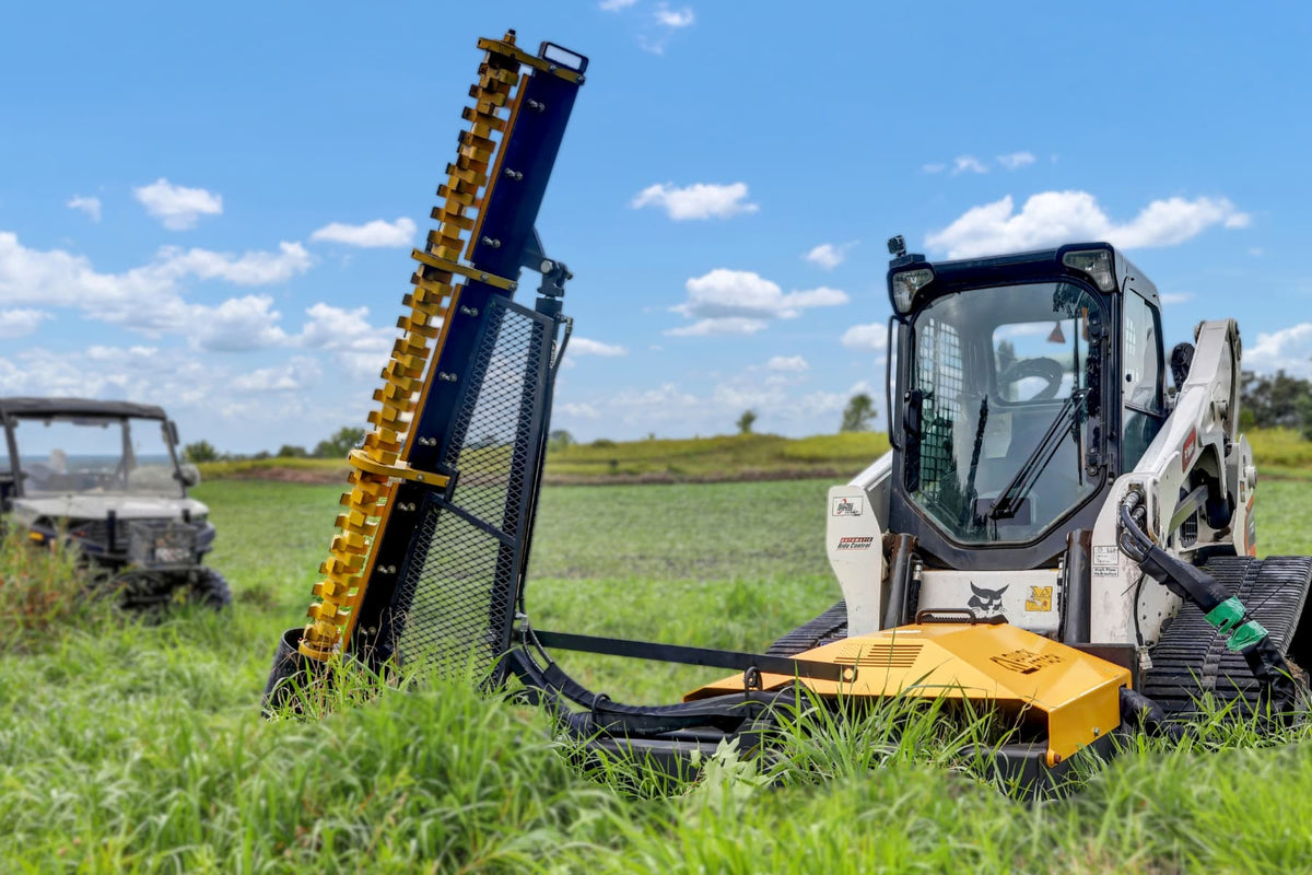 Limb Cutter 6 extended vertically from a skid steer in an open field.