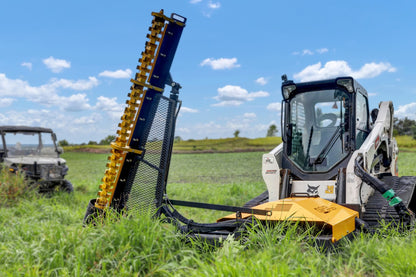 Limb Cutter 6 extended vertically from a skid steer in an open field.