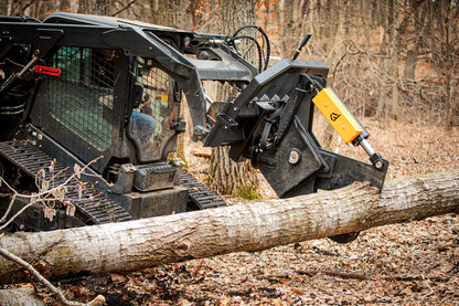 Heavy machinery with a tree shear attachment cutting through a log in a forest setting