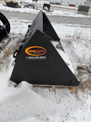 Black snow plow attachment on a pallet with 'Quick Attack' branding in a snowy outdoor setting.