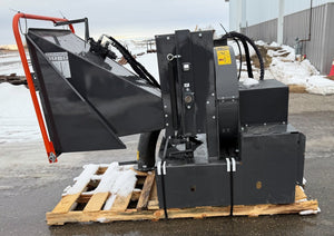 Heavy-duty attachments on a pallet outdoors with snow and a fence in the background