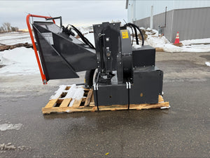 Heavy-duty attachments on a pallet outdoors with snow and a building in the background