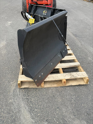 Large black excavator bucket on a wooden pallet outdoors