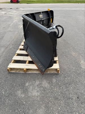 Black excavator bucket on a wooden pallet outdoors
