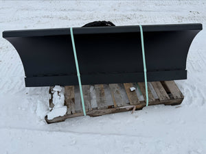Black snow plow on a wooden pallet in the snow