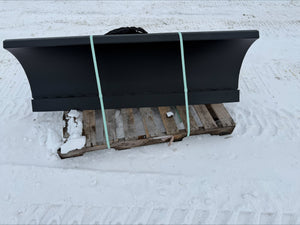 Black snow plow on a wooden pallet in the snow
