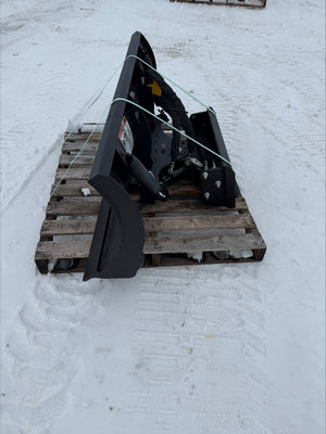 Black snow plow on a wooden pallet in a snowy area