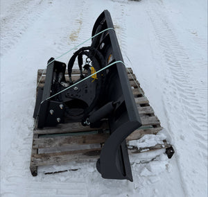 Black snowblower attachment on a wooden pallet in the snow