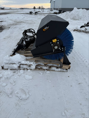 Snow removal equipment on a pallet in a snowy field