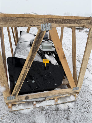 Wooden crate containing a black object on a snowy ground