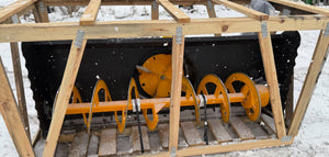 Snow removal machine with wooden frame on a snowy ground