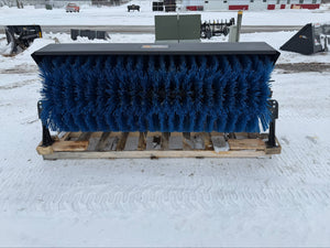 Large blue brush on a wooden pallet in a snowy outdoor setting
