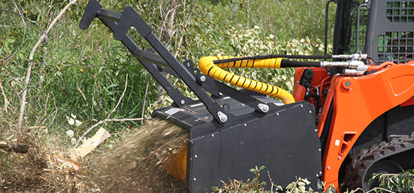 The skid steer Forestry Mulcher is a land clearing machine for breaking trails, leveling building sites, and clearing storm damage.